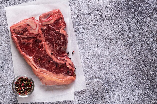 Bistecca con spinaci cruda fresca su sfondo di pietra grigia