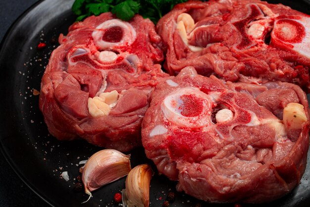 bistecca cruda collo di vitello sull'osso carne fresca su un piatto nero vista superiore nessuna gente