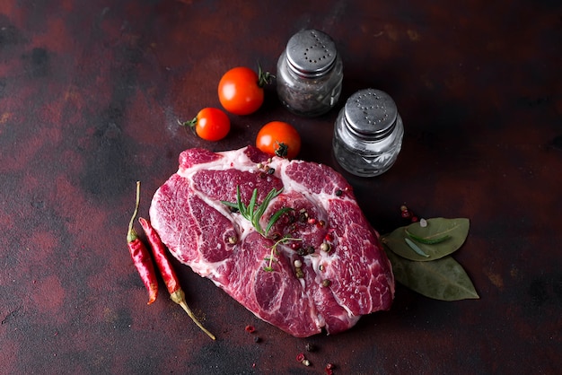 Bistecca cruda con spezie e ingredienti per cucinare.