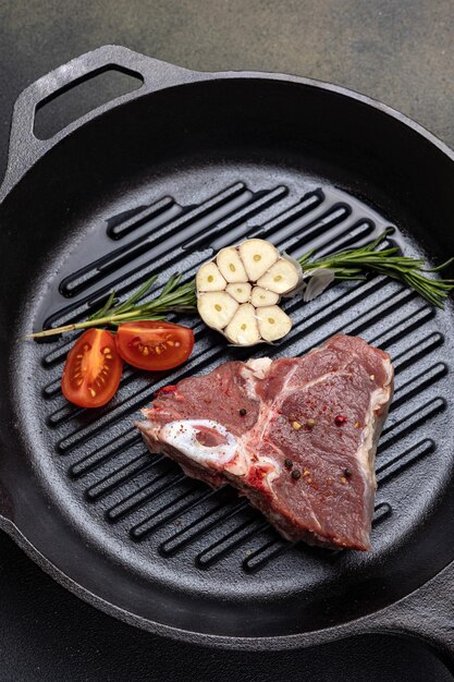 bistecca cruda con spezie in una padella di ghisa