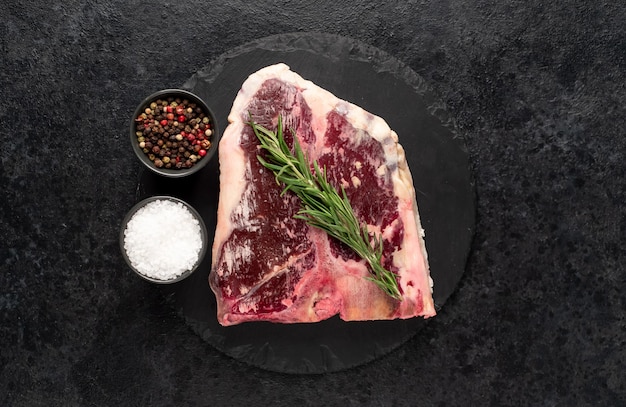 Bistecca cruda con spezie su uno sfondo di pietra bistecca essiccata con copia spazio per il testo