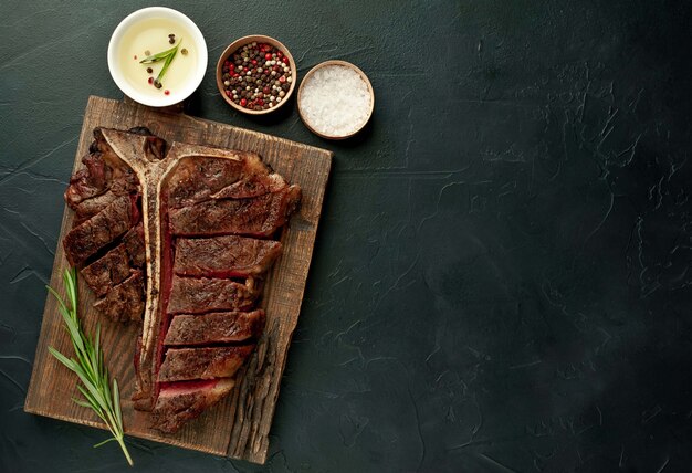 Bistecca di bistecca con l'osso arrostita su una tavola di pietra. Con copia spazio per il testo.