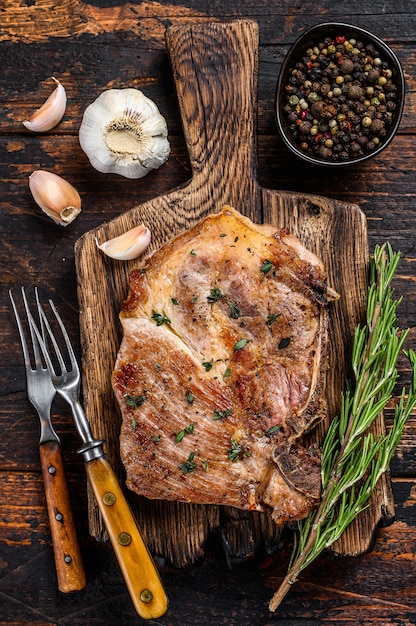 Bistecca di braciola di maiale arrosto su un tagliere