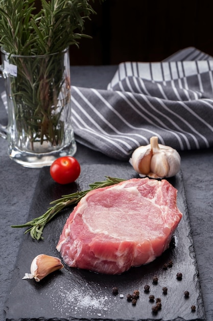 Bistecca di braciola di maiale crudo con sale e pepe. Copia spazio