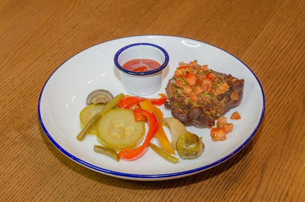 bistecca di carne alla griglia con verdure marinate e salsa