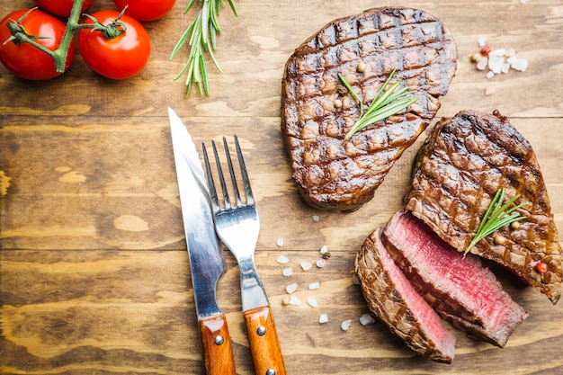 Bistecca di carne alla griglia Filet Mignon con condimenti. Bistecca di manzo succosa sul tagliere, vista dall'alto.