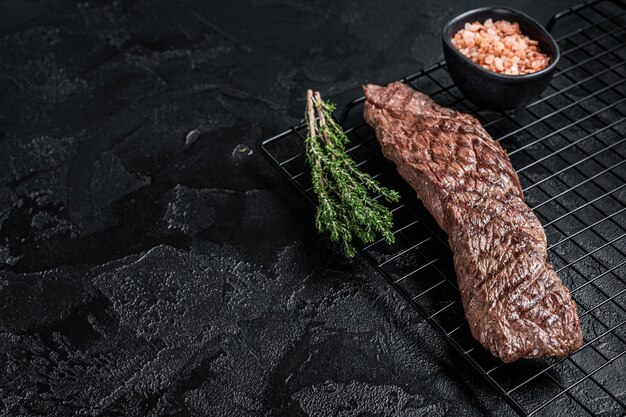 Bistecca di carne alla griglia Gonna machete su un rack Sfondo nero Vista dall'alto Copia spazio