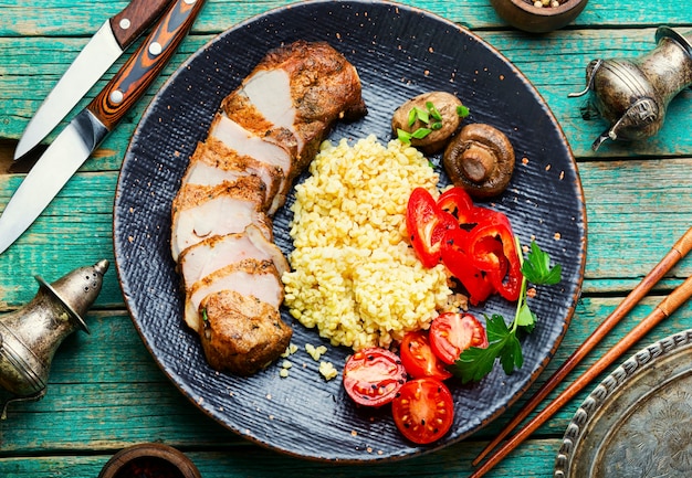 Bistecca di carne appetitosa con porridge di bulgur e verdure