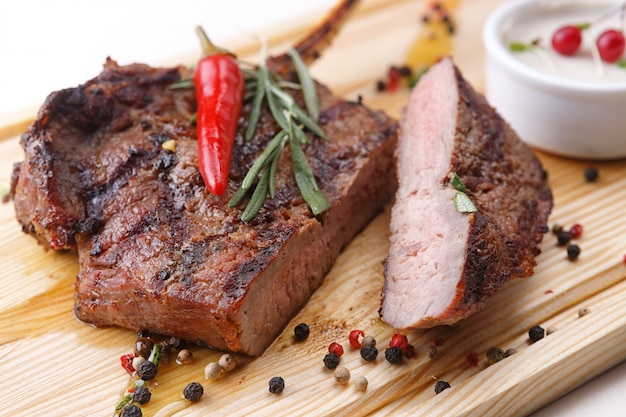 Bistecca di carne con salsa su una tavola di legno