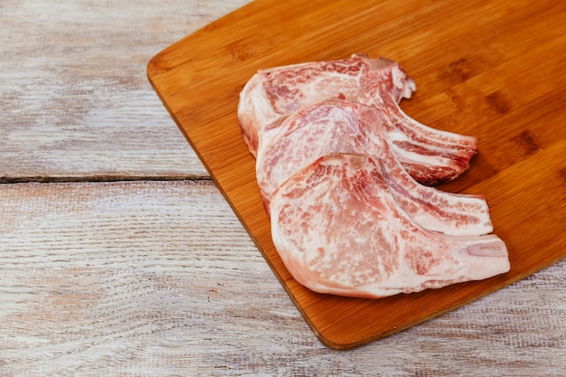 Bistecca di carne cruda sul bordo di legno scuro.