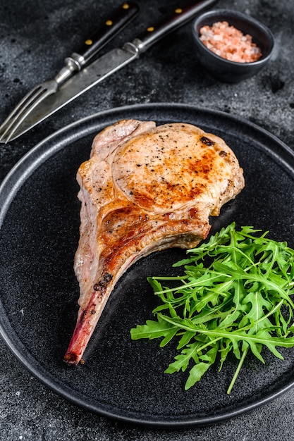 Bistecca di carne di lombo di braciola di maiale alla griglia su una tavola di marmo