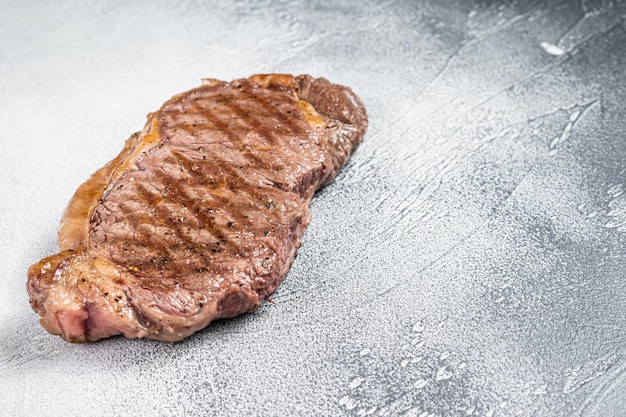 Bistecca di carne di manzo di New York alla griglia Sfondo bianco Vista dall'alto Spazio di copia