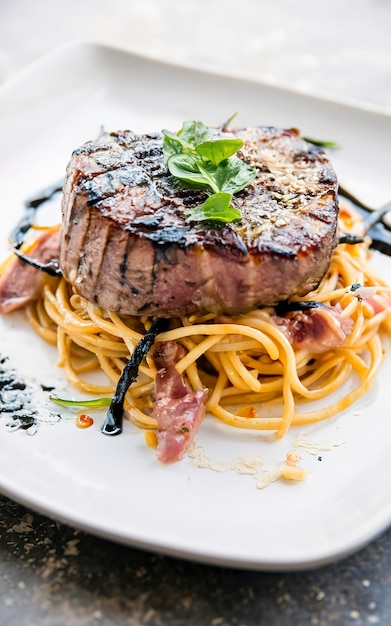 Bistecca di carne di tonno alla griglia con spaghetti neri a focale morbido