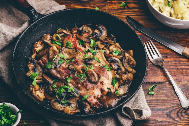 Bistecca di collo di maiale fritta con diversi funghi