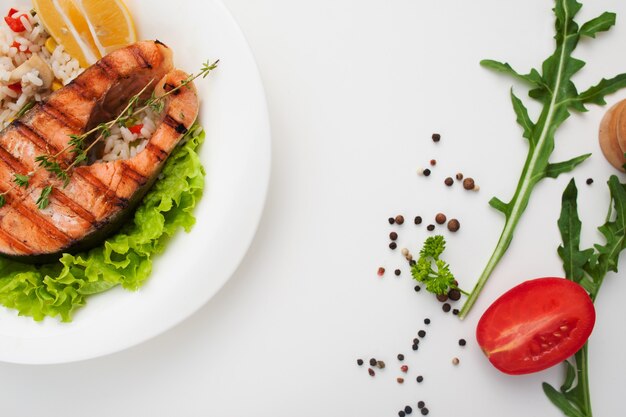 Bistecca di color salmone alla griglia sul tavolo bianco