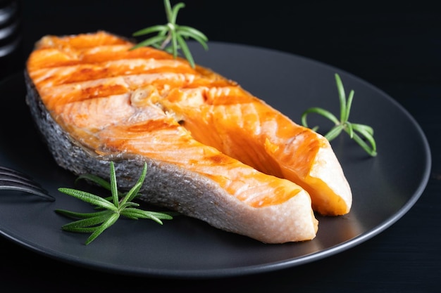 Bistecca di color salmone fritta sulla tavola di legno nera