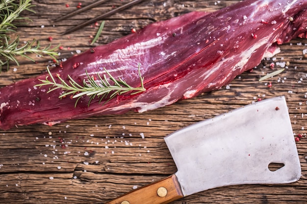 Bistecca di filetto di manzo crudo su tagliere con sale pepe rosmarino in altre posizioni