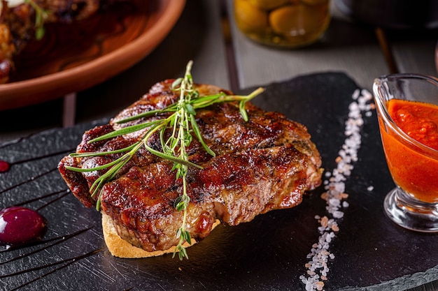 Bistecca di maiale alla griglia, adagiata su un pezzo di pane bianco