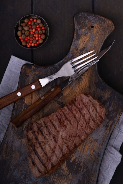 Bistecca di manzo alla griglia con coltello e forchetta sul tagliere