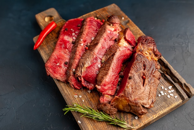 Bistecca di manzo alla griglia con erbe e spezie su uno sfondo di pietra