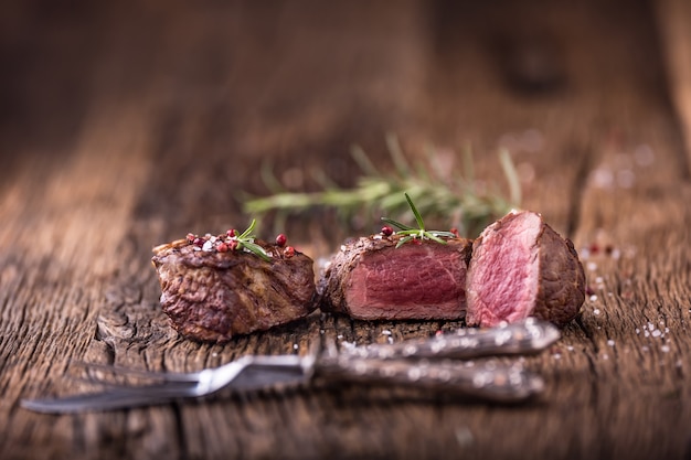 Bistecca di manzo alla griglia con rosmarino, sale e pepe sul vecchio tagliere. Bistecca di filetto di manzo.