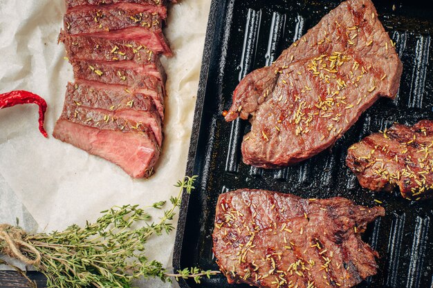 Bistecca di manzo alla griglia in padella, vista dall&#39;alto. Pezzi fritti di carne da vicino