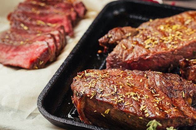 Bistecca di manzo alla griglia in padella, vista dall&#39;alto. Pezzi fritti di carne da vicino