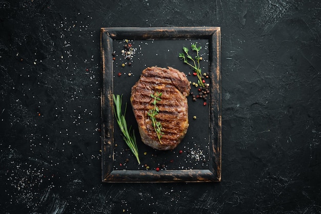 Bistecca di manzo alla griglia mediamente cotta su un tavolo di pietra nera Vista dall'alto Spazio libero per il testo