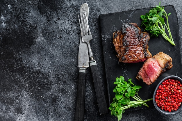 Bistecca di manzo alla griglia. Sfondo nero