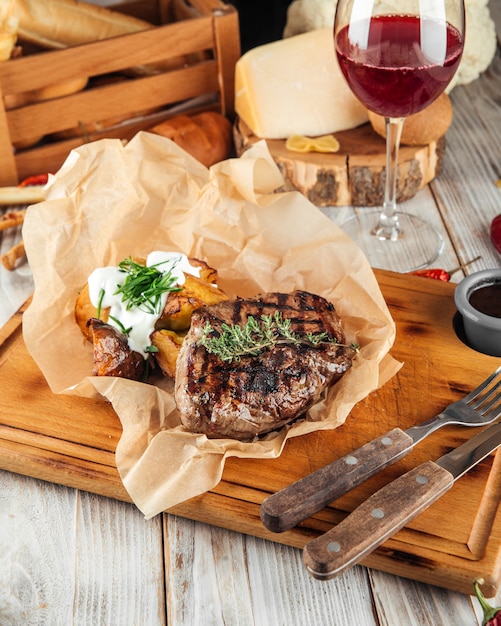 Bistecca di manzo con patate al forno e panna acida