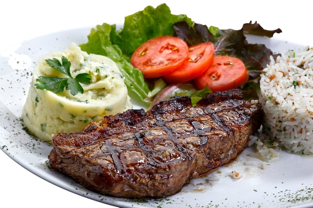 Bistecca di manzo con patate e riso in fondo bianco isolato