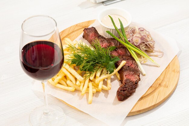 Bistecca di manzo con patatine fritte, erbe e vino rosso