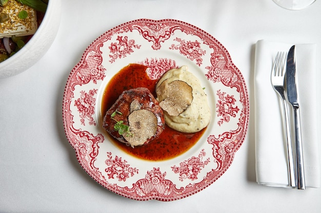 Bistecca di manzo con purè di patate in salsa su un bel piatto di porcellana