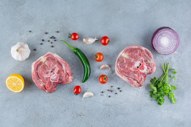 Bistecca di manzo cruda e verdure fresche sul tavolo di pietra.