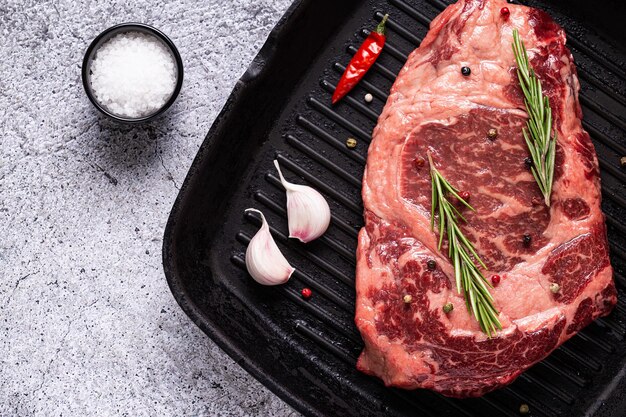 Bistecca di manzo cruda fresca sulla padella per grigliare