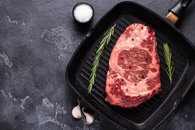 Bistecca di manzo cruda fresca sulla vista dall'alto della padella della griglia