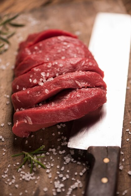 Bistecca di manzo cruda su un tavolo di legno scuro.