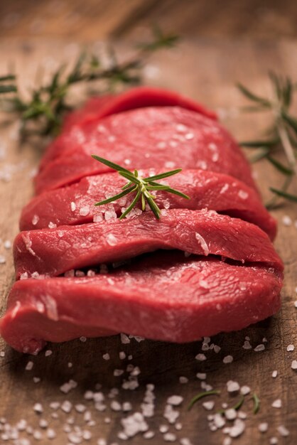 Bistecca di manzo cruda su un tavolo di legno scuro.