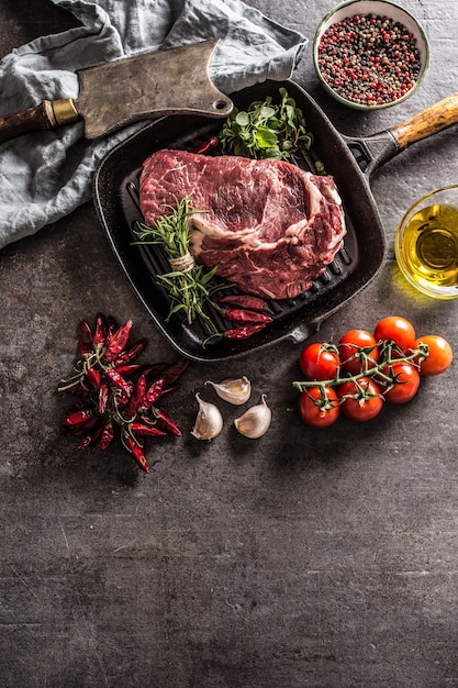 Bistecca di manzo in padella con rosmarino origano sale pepe spezie aglio e pomodori.