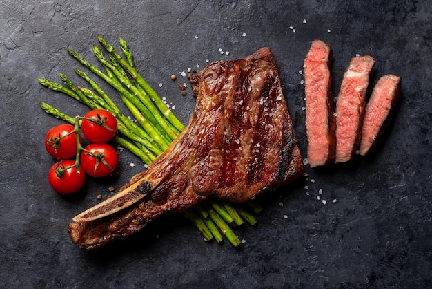 Bistecca di manzo Tomahawk alla griglia mediamente rara con asparagi