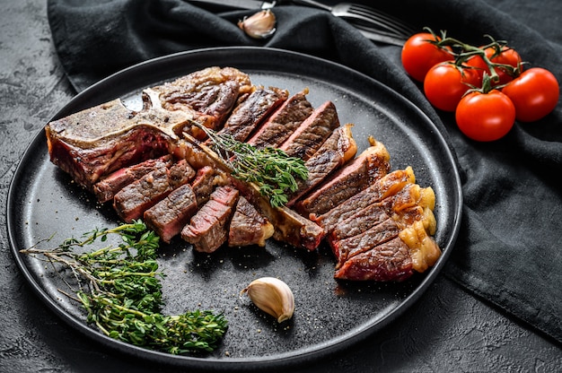 Bistecca di Porterhouse alla griglia su un tagliere. Carne di manzo cotta. Spazio in legno bianco. Vista dall'alto