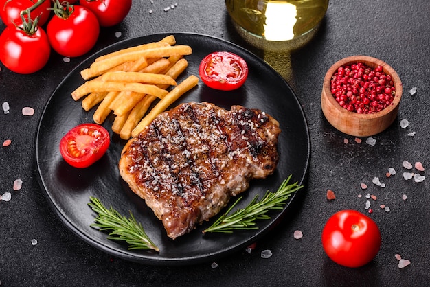 Bistecca di Ribeye con patate, cipolle e pomodorini. Bistecca succosa con burro aromatizzato