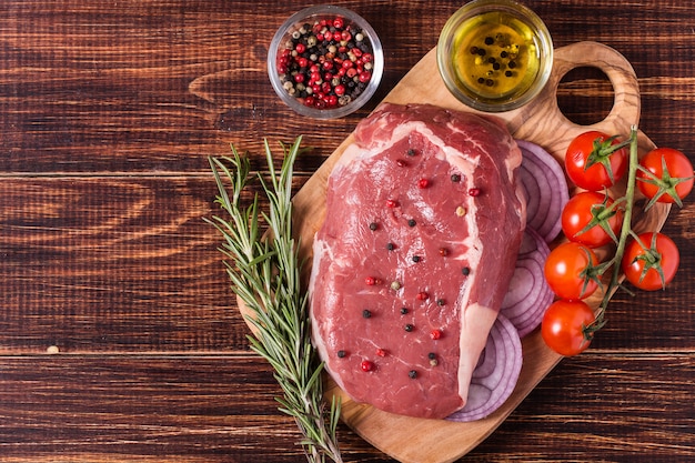 Bistecca di Ribeye fresca cruda con pepe su una tavola di legno