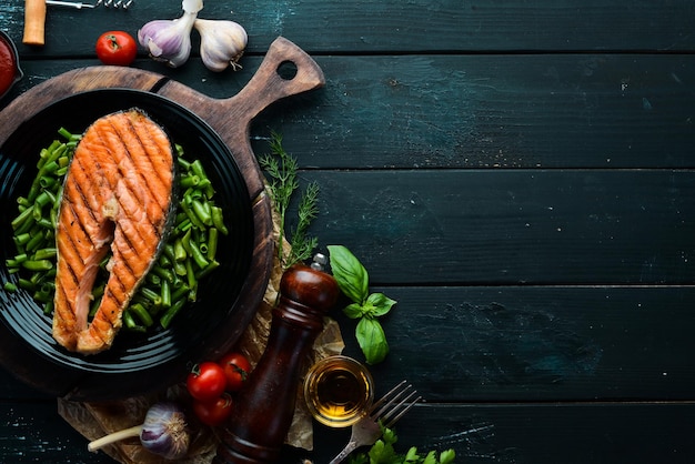 Bistecca di salmone al forno con fagiolini su un piatto nero Vista dall'alto Spazio di copia gratuito