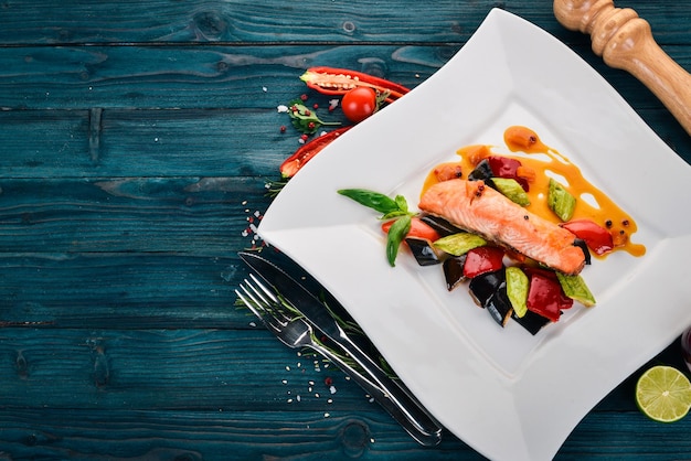 Bistecca di salmone al forno con verdure su sfondo di legno Vista dall'alto Spazio di copia