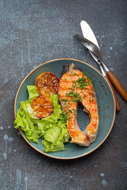 bistecca di salmone alla griglia e insalata verde con limone