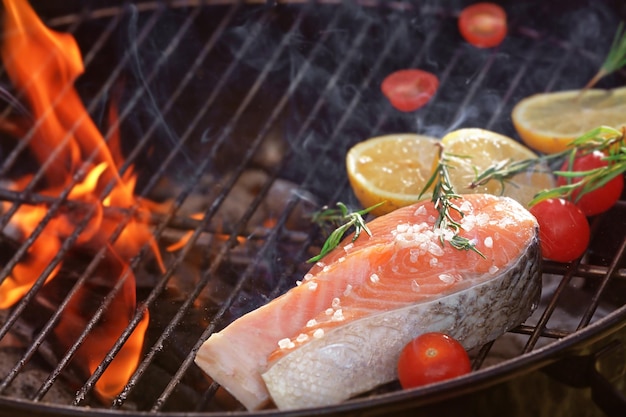 Bistecca di salmone con limone e rosmarino sulla griglia del barbecue da vicino