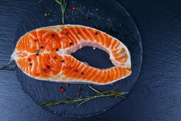 Bistecca di salmone crudo con spezie su ardesia nera Vista dall'alto