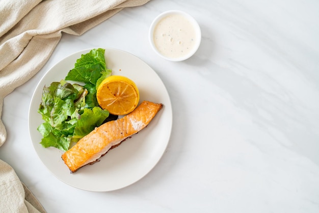 Bistecca di salmone fritta fatta in casa con stile alimentare sano limone e verdura