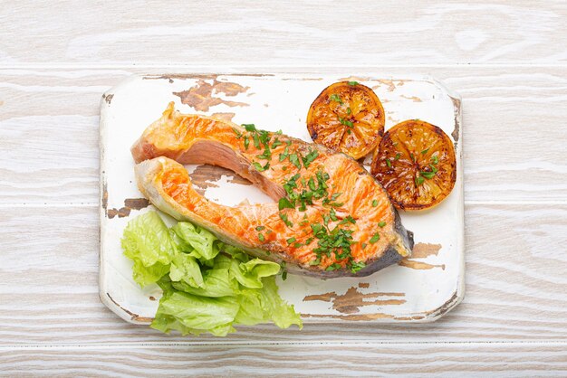 bistecca di salmone grigliato e insalata verde con limone servita